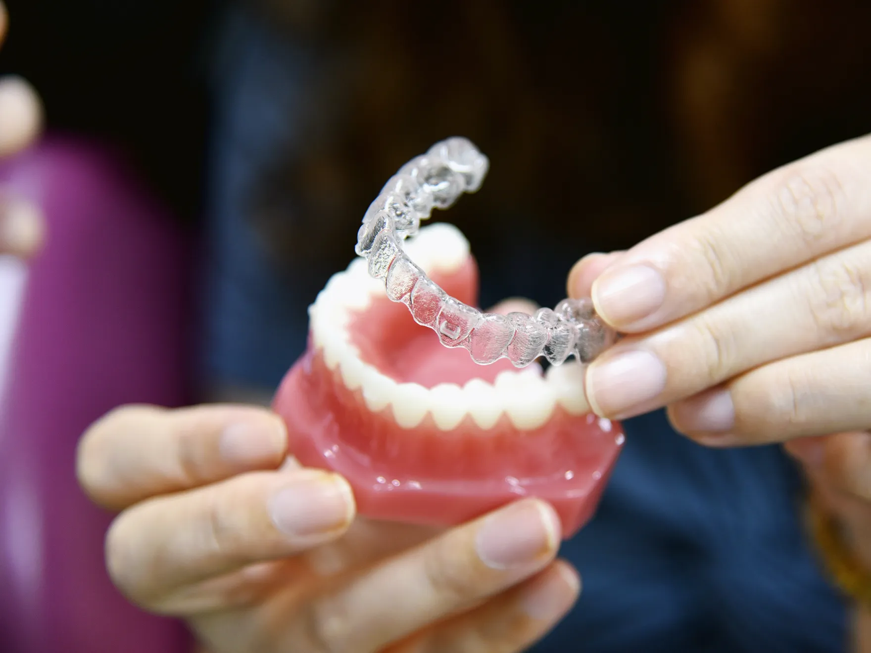 a person holding an invisalign in their hand